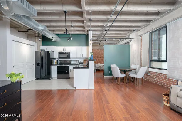 a kitchen with stainless steel appliances granite countertop a refrigerator a stove and a wooden floors