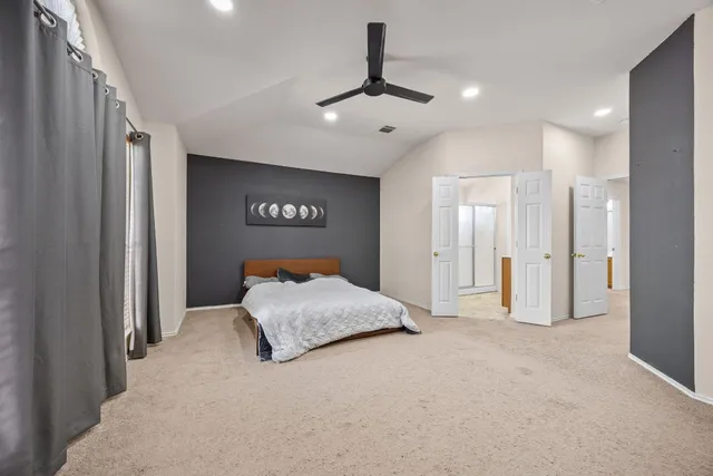 a spacious bedroom with a bed and a chandelier