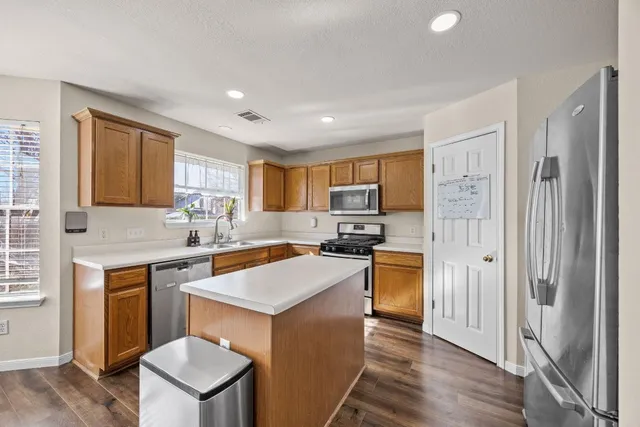 a kitchen with a refrigerator a sink dishwasher with a dining table and chairs