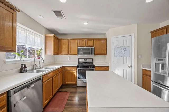 a kitchen with stainless steel appliances granite countertop a stove sink and cabinets