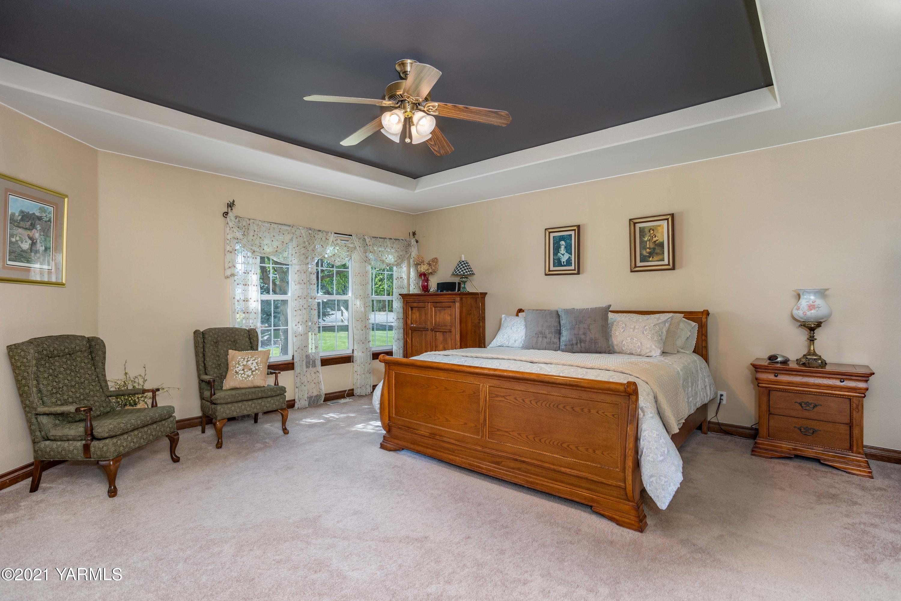 3131 Scoon Road Sunnyside, WA 98944 - Photo 14 of 33 a spacious bedroom with a bed and a chandelier