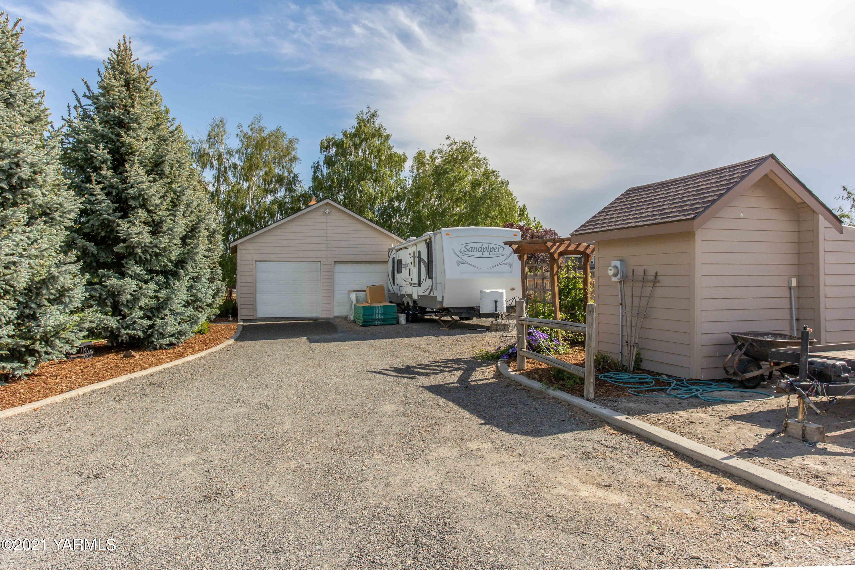 3131 Scoon Road Sunnyside, WA 98944 - Photo 29 of 33 a backyard of a house with table and chairs under an umbrella