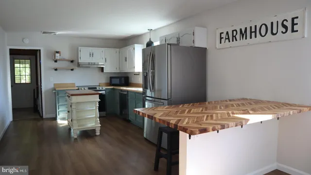 a kitchen with a refrigerator and a stove top oven