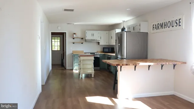 a kitchen with stainless steel appliances kitchen island sink refrigerator and microwave