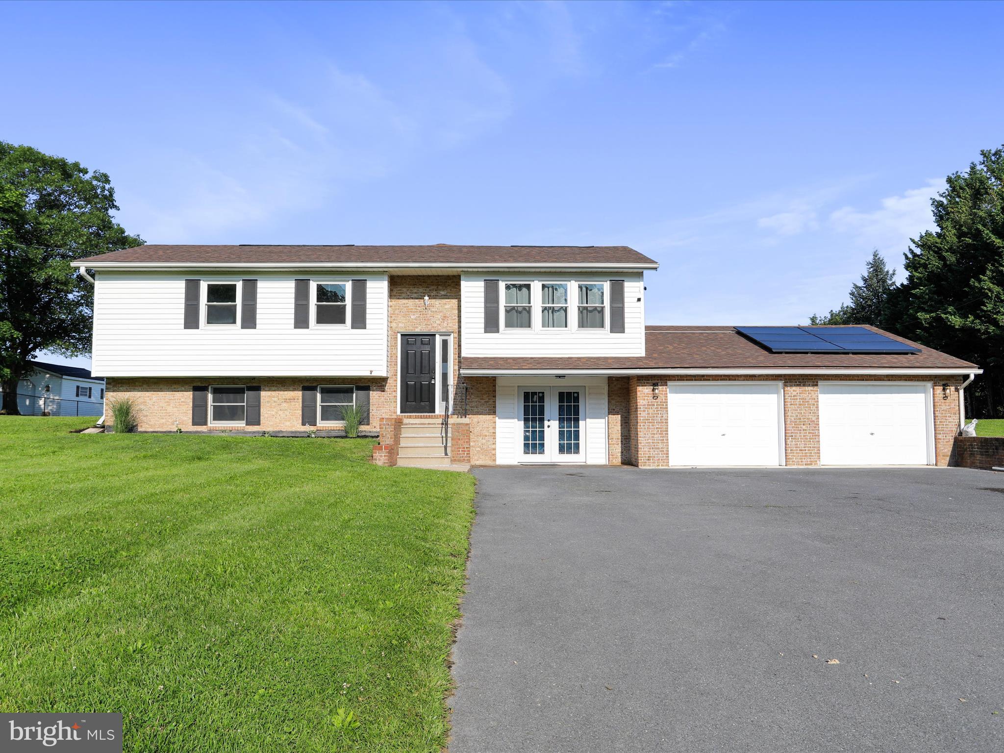 8175 Stone Bridge Road Greencastle, PA 17225 - Photo 2 of 44 a front view of a house with a garden and yard