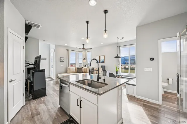 a kitchen with stainless steel appliances granite countertop a sink a counter space and refrigerator
