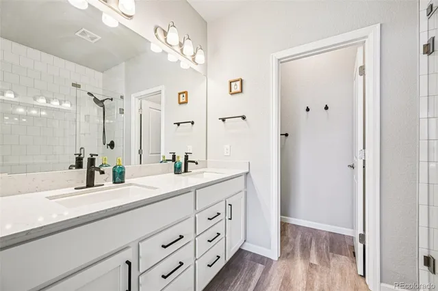a bathroom with a double vanity sink mirror and shower