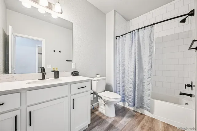 a spacious bathroom with a double vanity sink a toilet and a bathtub