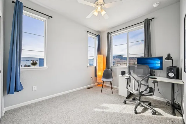 a view of a workspace with furniture and a window