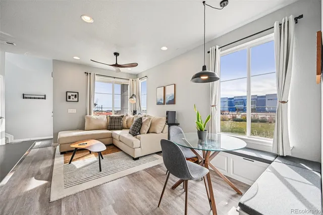 a living room with furniture a chandelier and a floor to ceiling window
