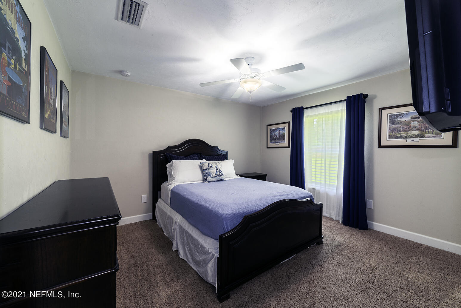 12052 Southwest 2nd Road Gainesville, FL 32607 - Photo 20 of 31 a bedroom with a bed and a chandelier