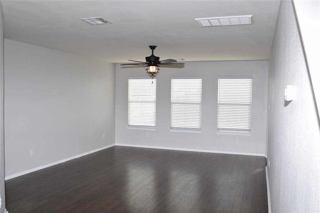 375 Housefinch Loop Leander, TX 78641 - Photo 3 of 28 Rich dark wood floors anchor this open space beneath a smooth clean ceiling.