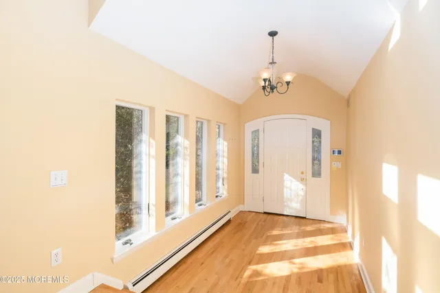 a kitchen with kitchen island granite countertop a sink and white cabinets with wooden floor
