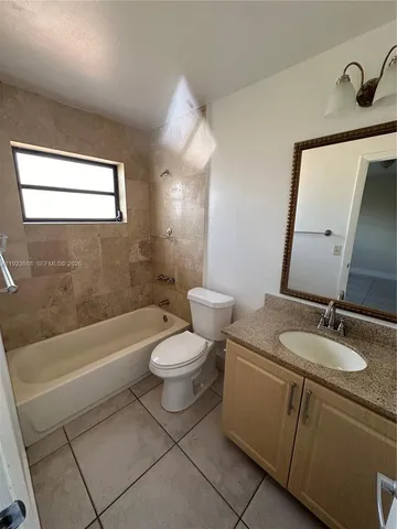 a bathroom with a sink a toilet a mirror and bathtub