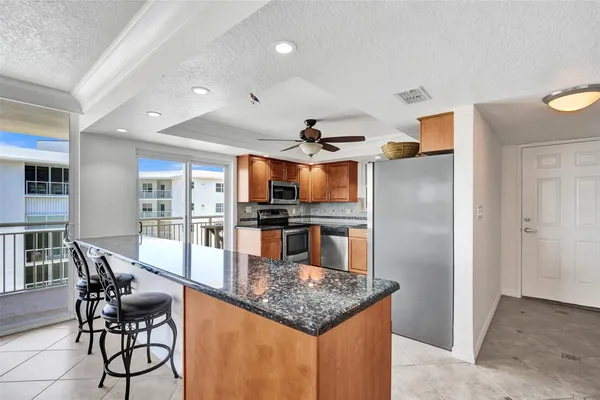 a kitchen with stainless steel appliances granite countertop a refrigerator a stove and a sink