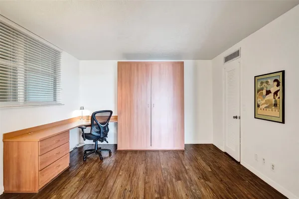 a view of a workspace with furniture and a window