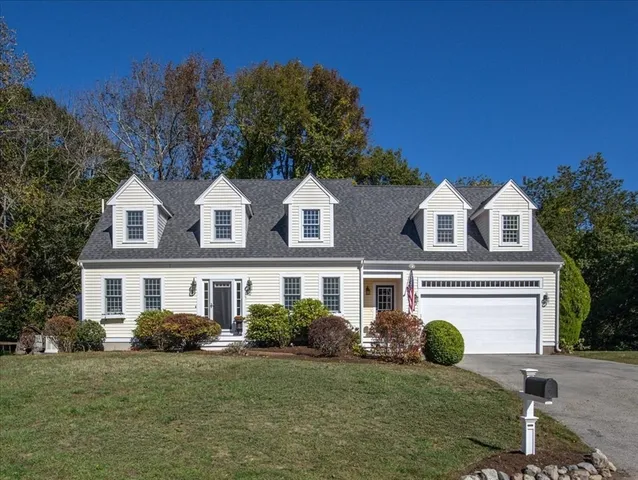a view of a white house with a big yard and large trees