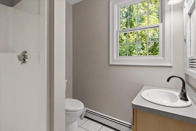 a bathroom with a sink a toilet and a window