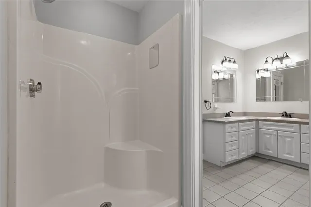 a bathroom with a granite countertop sink a toilet and shower