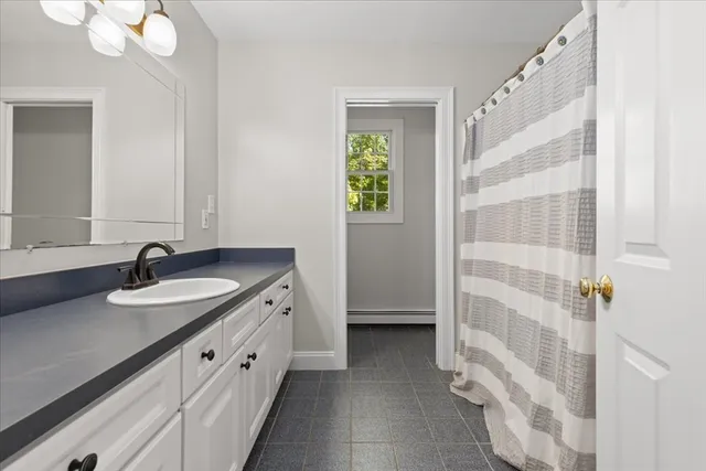 a bathroom with a granite countertop sink and a mirror