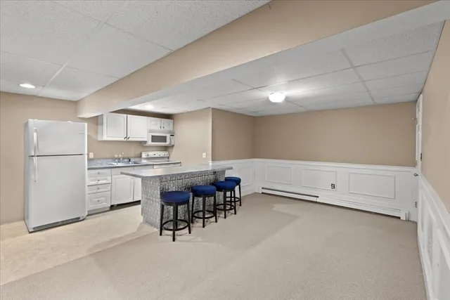 a kitchen with white cabinets and white appliances