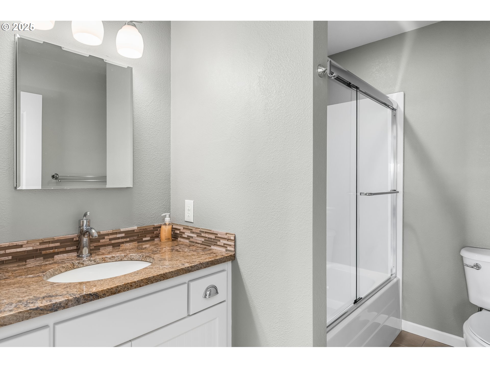 2053 Lakeview Drive Eugene, OR 97408 - Photo 21 of 45 a bathroom with a granite countertop sink a toilet and a mirror