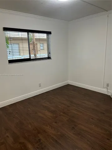 a view of a room with wooden floor and a window