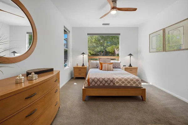 a bedroom with a bed a mirror and a window