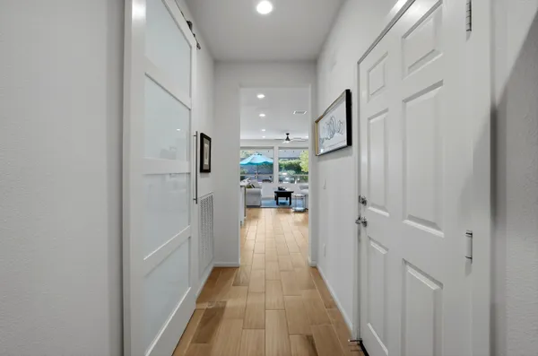 a view of a hallway with a dining table & chairs