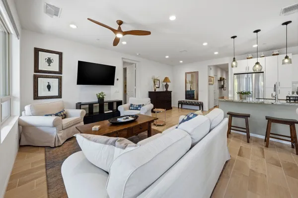 a living room with furniture kitchen view and a flat screen tv