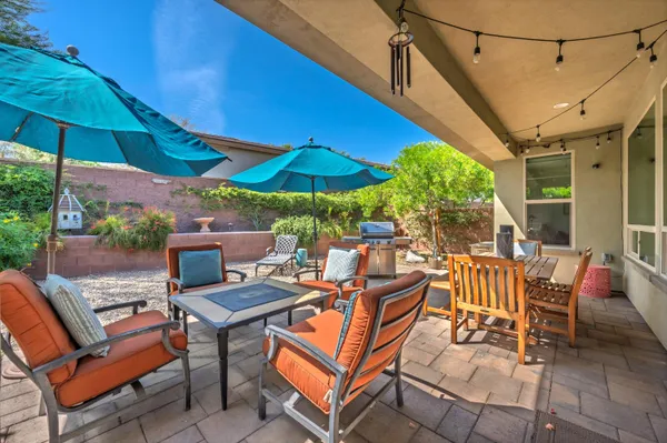 a view of a patio with a table and chairs under an umbrella