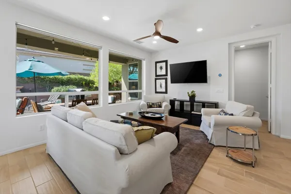 a living room with furniture a flat screen tv and a large window