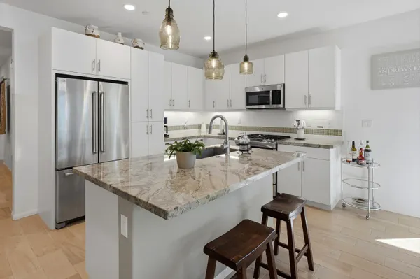 a kitchen with stainless steel appliances granite countertop a sink refrigerator and cabinets