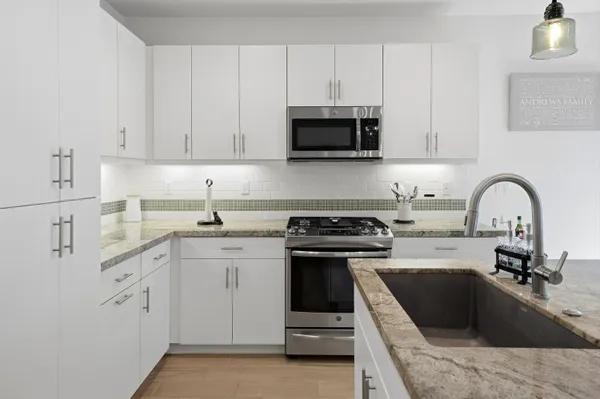 a kitchen with white cabinets a sink and appliances