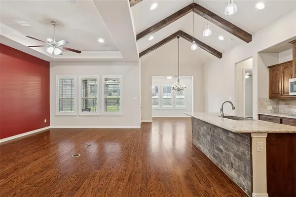 a view of a big room with wooden floor and a window