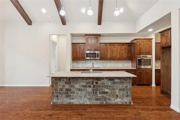 a kitchen with stainless steel appliances granite countertop a stove a sink and a refrigerator