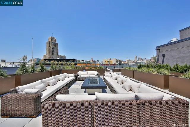 a view of roof deck with couches and city view