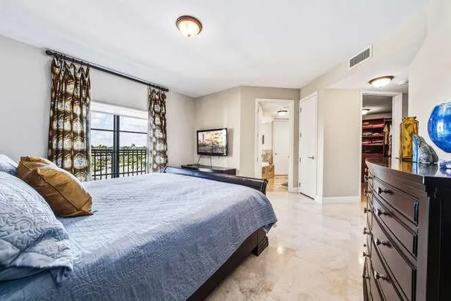 a bedroom with a bed and a large window