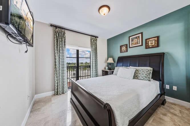 2401 North Ocean Boulevard, Unit 500 Fort Lauderdale, FL 33305 - Photo 18 of 38 a bedroom with a large bed and a chandelier