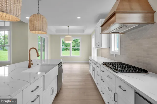 a kitchen with granite countertop a stove a sink a window and cabinetry