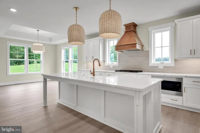 a kitchen with stainless steel appliances granite countertop a sink a window and a wooden floor