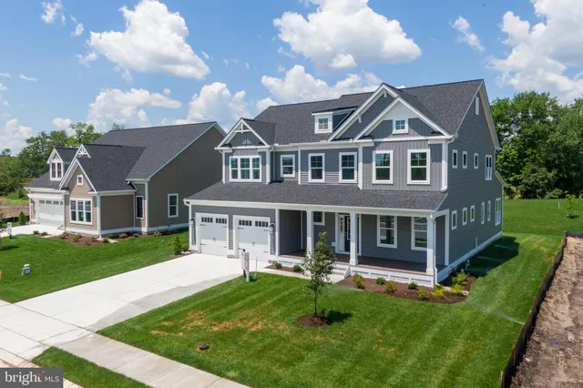 a front view of a house with yard and green space