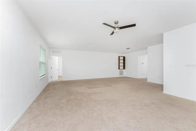 an empty room with a window and a fan