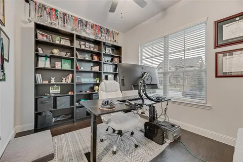 a view of a workspace with furniture and a window