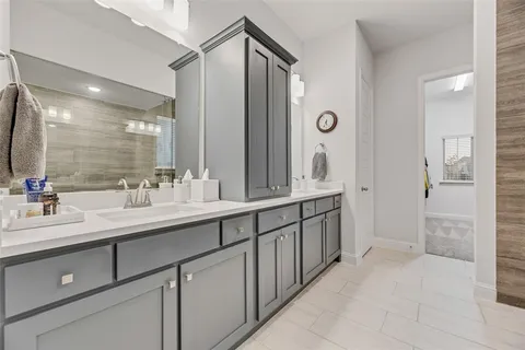 a spacious bathroom with double sink and a mirror