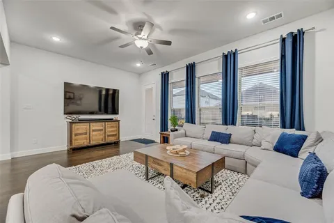 a living room with furniture a flat screen tv and a large window
