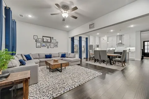 a living room with furniture and view of kitchen