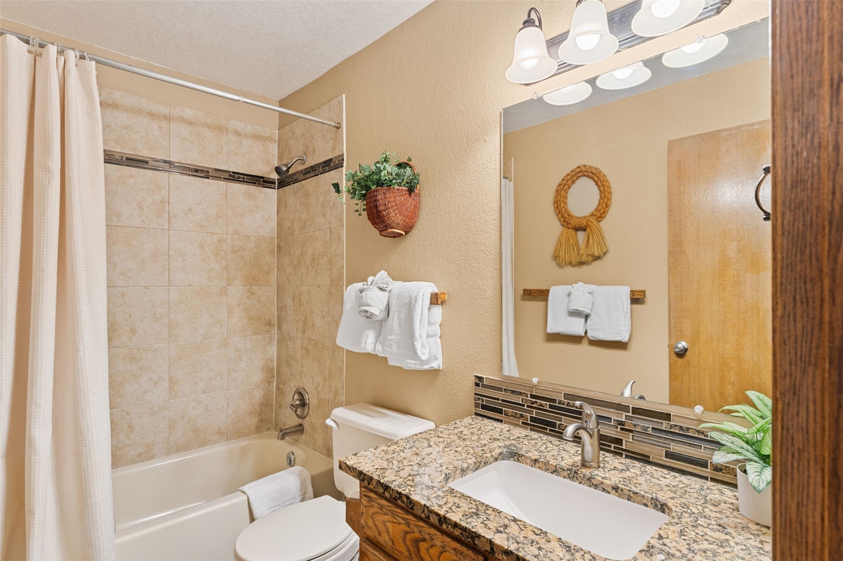 89410 Ryan Gulch Road, Unit DD301 Silverthorne, CO 80498 - Photo 17 of 28 a bathroom with a granite countertop sink a mirror and a bathtub
