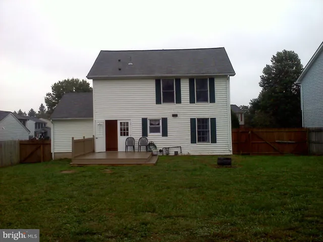 a front view of house with a garden and trees