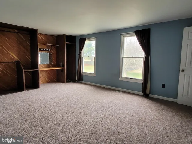 an empty room with windows and closet